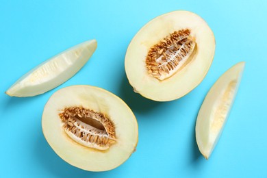 Photo of Fresh cut melon on light blue background, flat lay