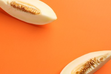 Photo of Fresh cut melon on orange background, top view. Space for text