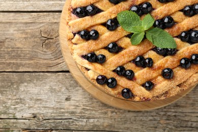 Photo of Delicious homemade blueberry pie with mint on wooden table, top view