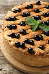 Photo of Delicious homemade blueberry pie with mint on wooden table, closeup