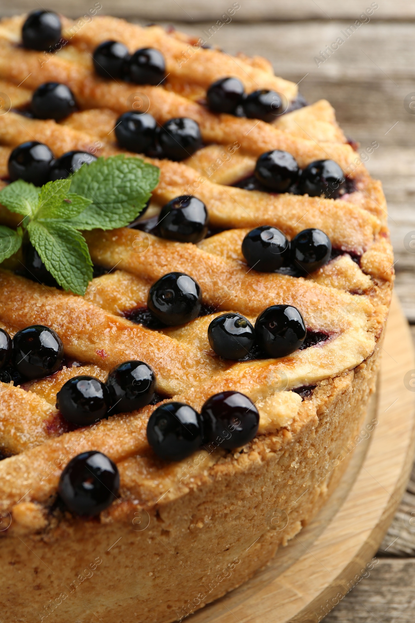 Photo of Delicious homemade blueberry pie with mint on table, closeup