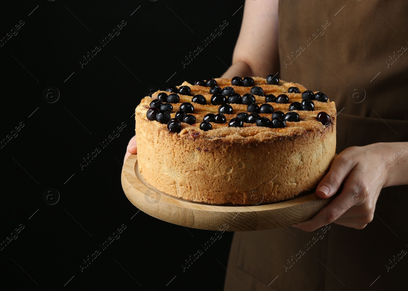 Photo of Woman with delicious homemade blueberry pie on black background, closeup