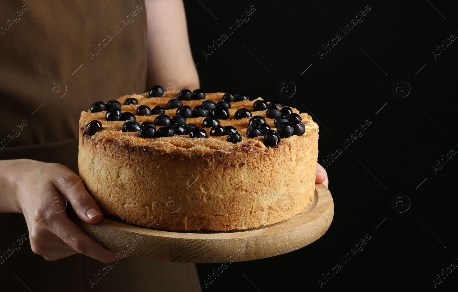 Photo of Woman with delicious homemade blueberry pie on black background, closeup