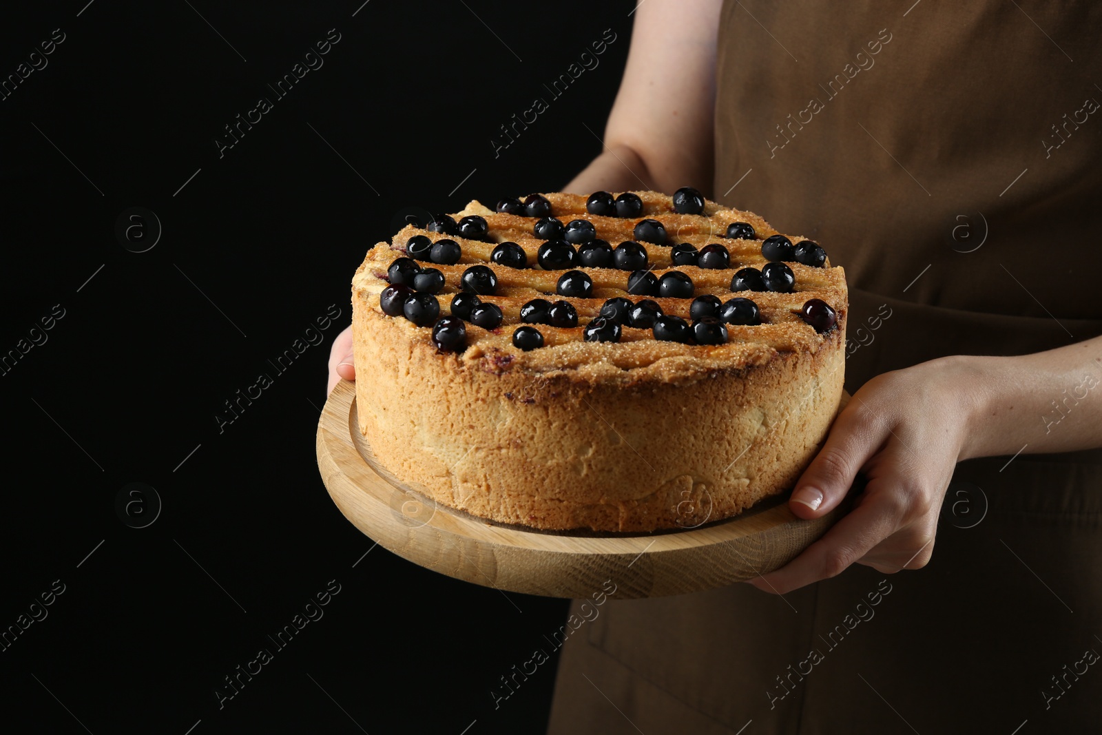 Photo of Woman with delicious homemade blueberry pie on black background, closeup