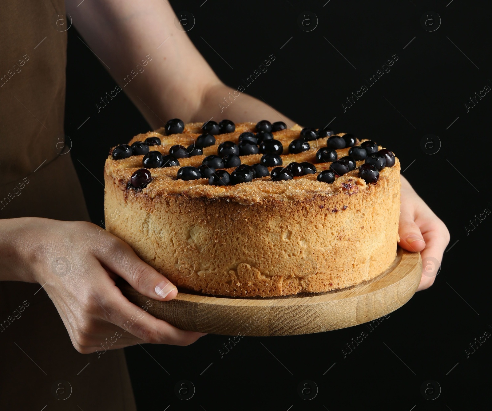 Photo of Woman with delicious homemade blueberry pie on black background, closeup