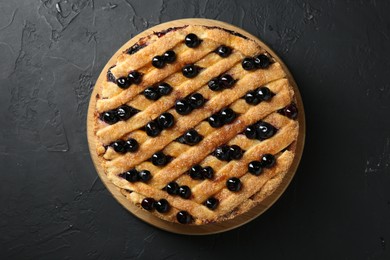 Photo of Delicious homemade blueberry pie on black table, top view