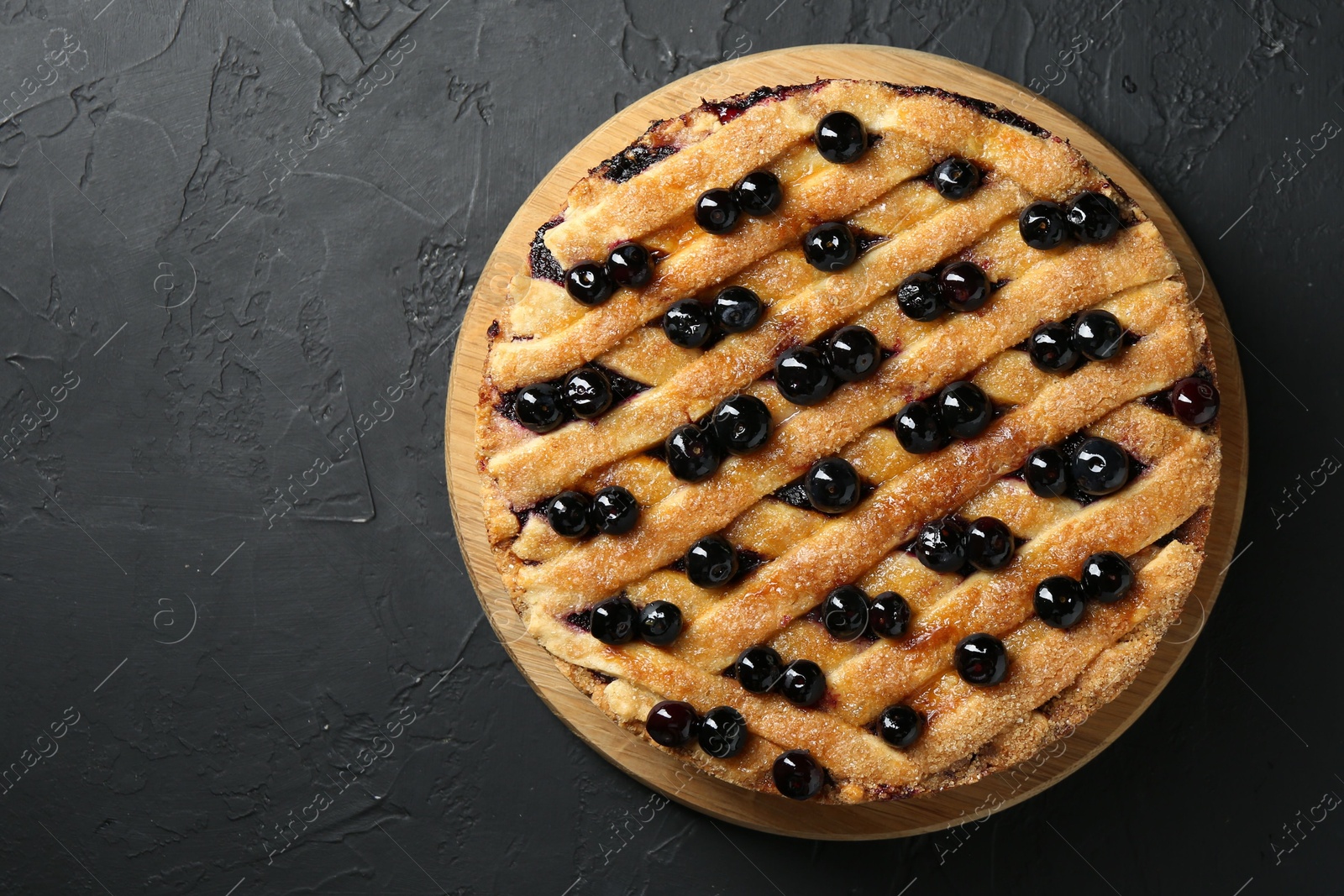 Photo of Delicious homemade blueberry pie on black table, top view. Space for text