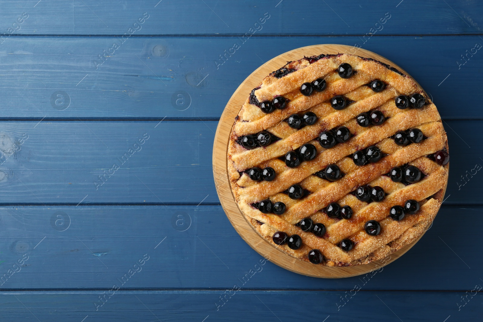 Photo of Delicious homemade blueberry pie on blue wooden table, top view. Space for text