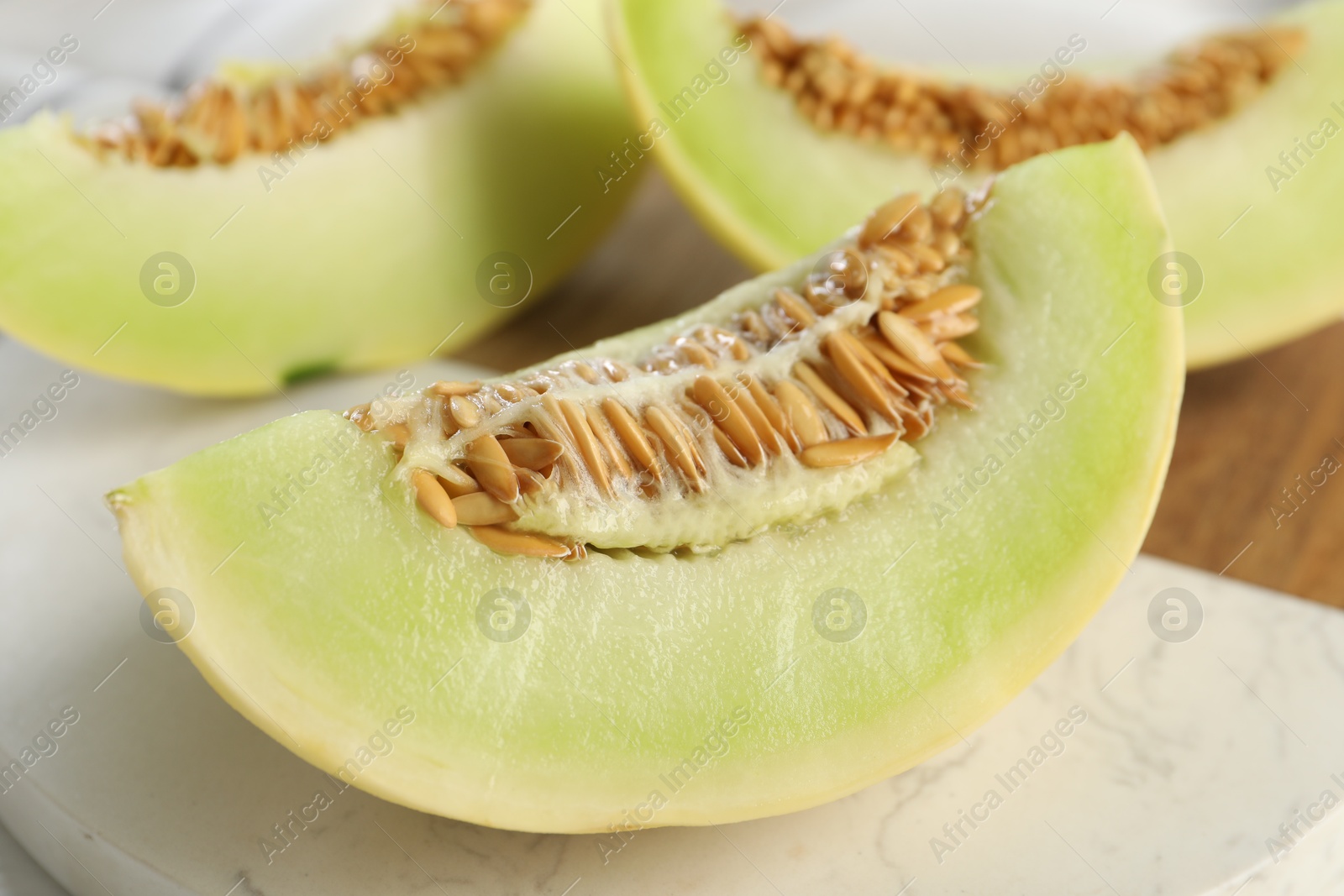 Photo of Fresh cut honeydew melon on table, closeup