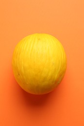 Photo of One fresh melon on orange background, top view