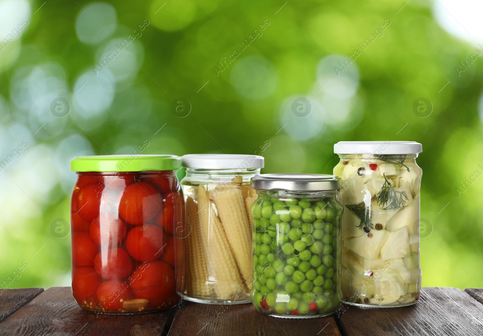 Image of Jars with pickled vegetables on wooden table outdoors, space for text