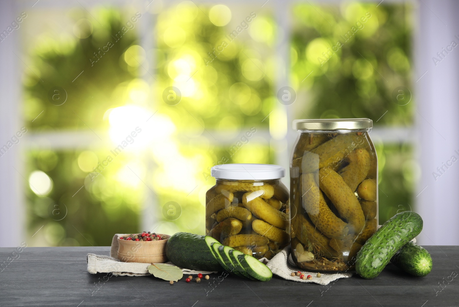 Image of Jars with pickled cucumbers on table indoors, space for text