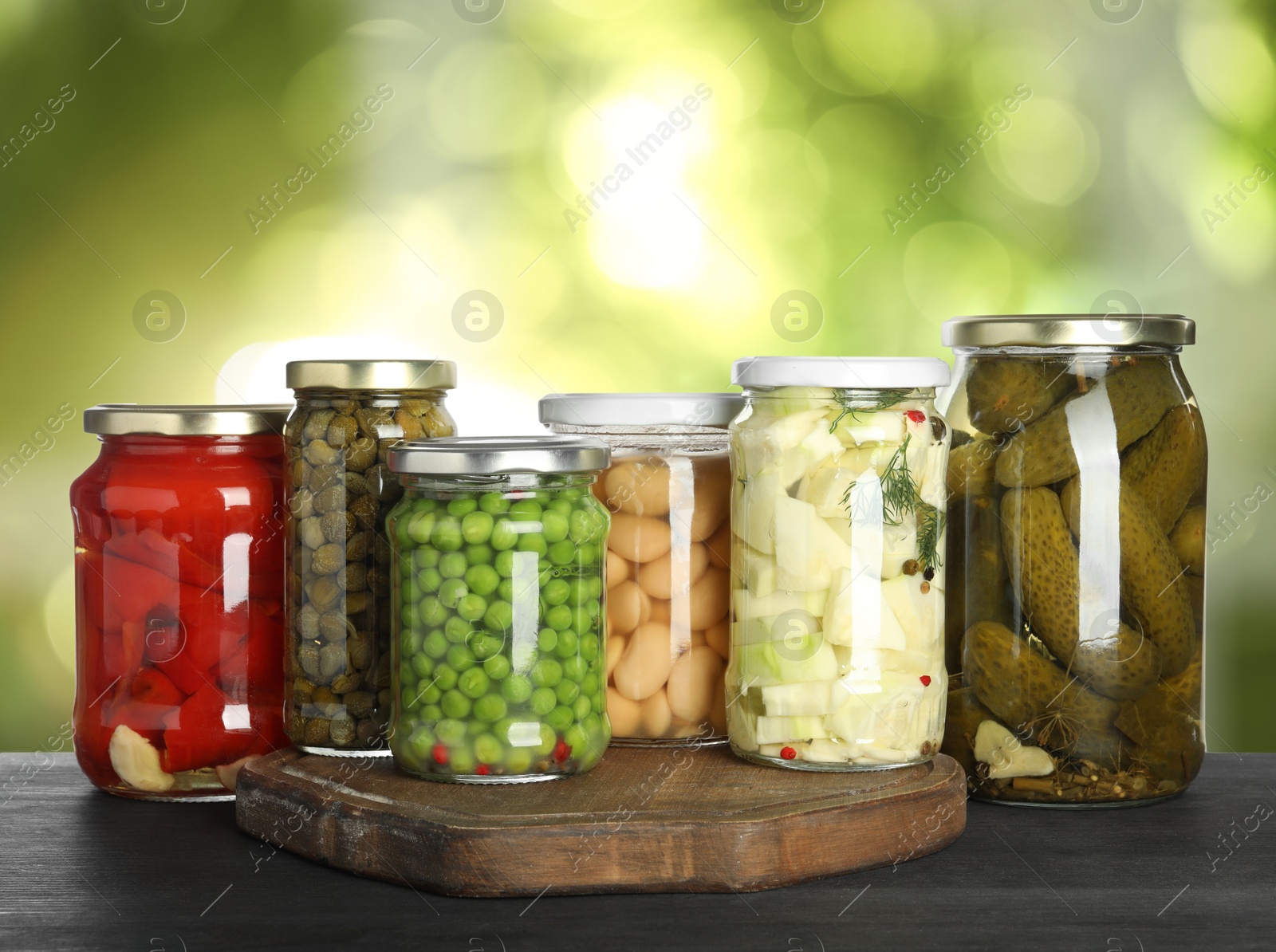 Image of Jars with pickled vegetables on table outdoors, space for text