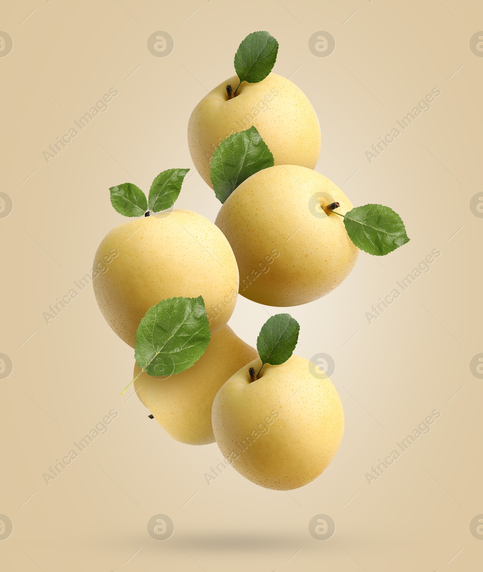 Image of Fresh apple pears and green leaves falling on dark beige background