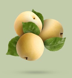 Image of Fresh apple pears and green leaves falling on greyish green background