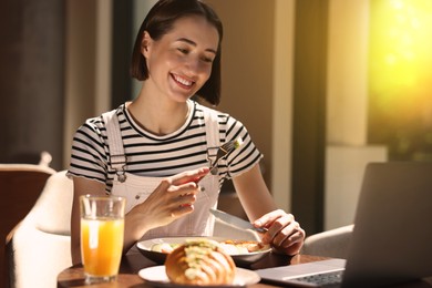 Image of Happy woman having tasty breakfast in cafe on sunny morning