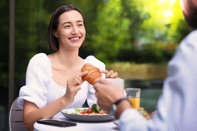 Image of Happy couple having breakfast at outdoor cafe on sunny morning