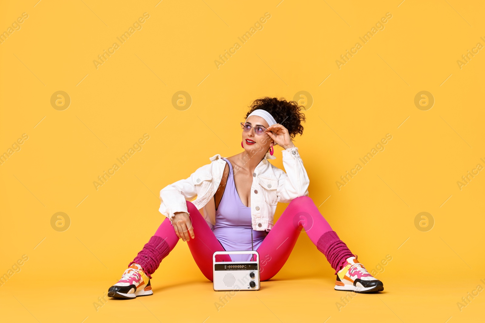 Photo of Aerobics. Woman with radio receiver on orange background