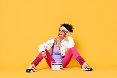 Photo of Aerobics. Woman with radio receiver on orange background