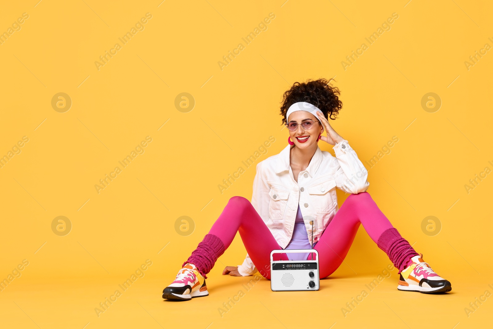 Photo of Aerobics. Woman with radio receiver on orange background