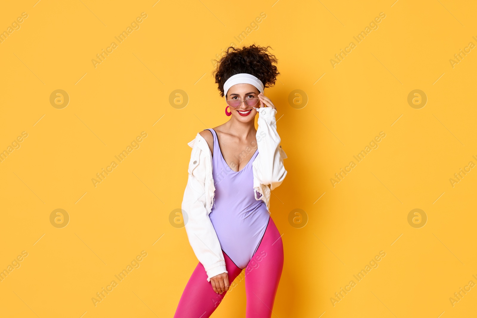 Photo of Aerobics. Happy woman in sportswear on orange background