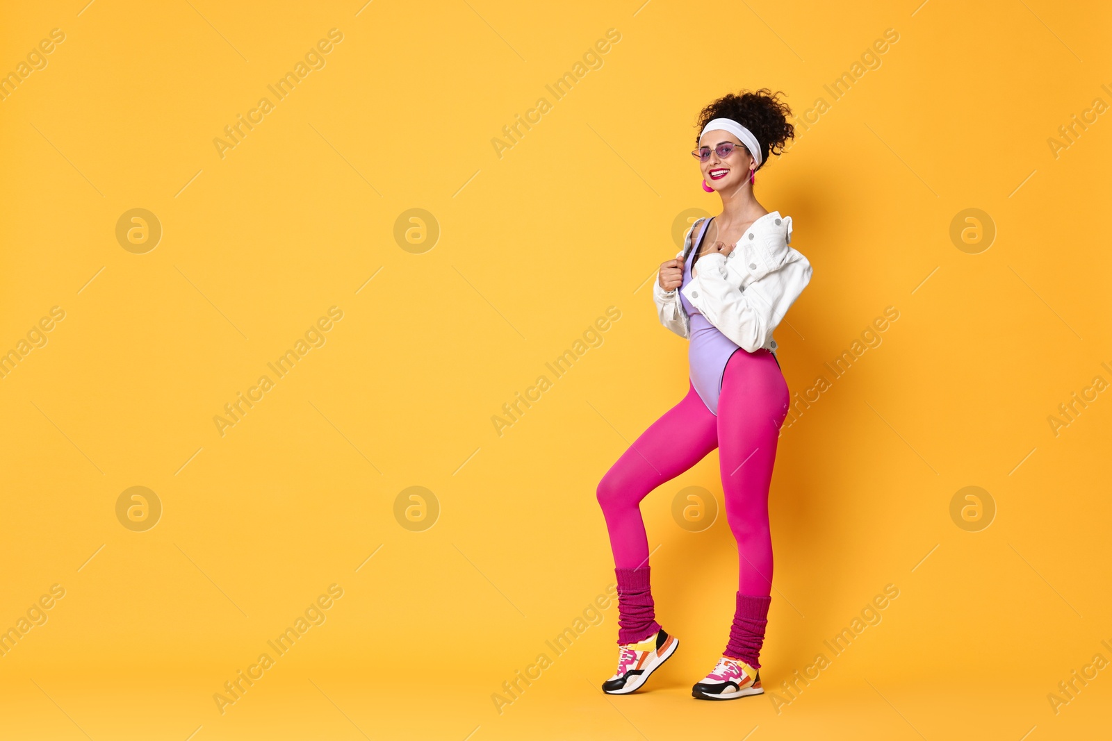 Photo of Aerobics. Happy woman in sportswear on orange background, space for text