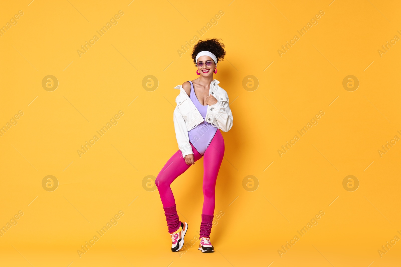 Photo of Aerobics. Happy woman in sportswear on orange background