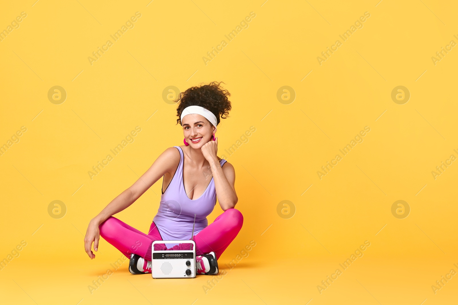 Photo of Aerobics. Woman with radio receiver on orange background, space for text