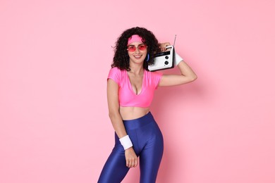 Aerobics. Woman with radio receiver on pink background