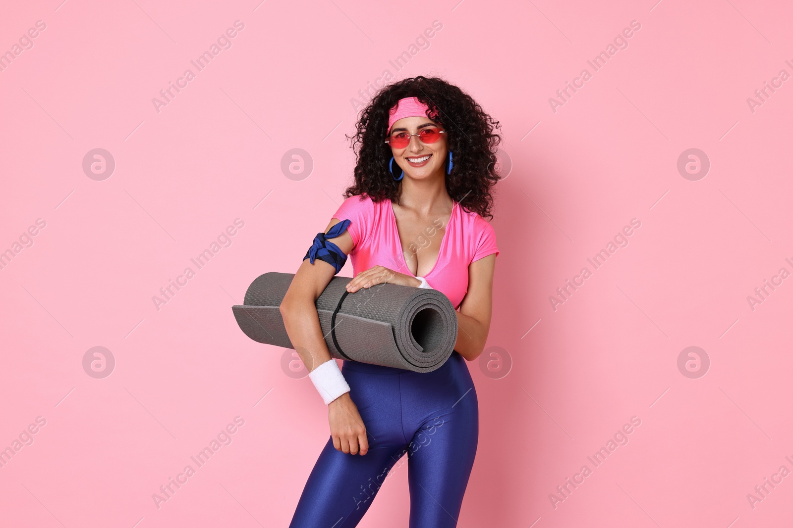 Photo of Aerobics. Happy woman with fitness mat on pink background