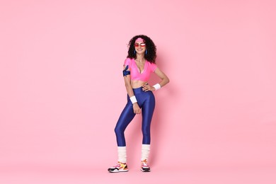 Aerobics. Happy woman in sportswear on pink background