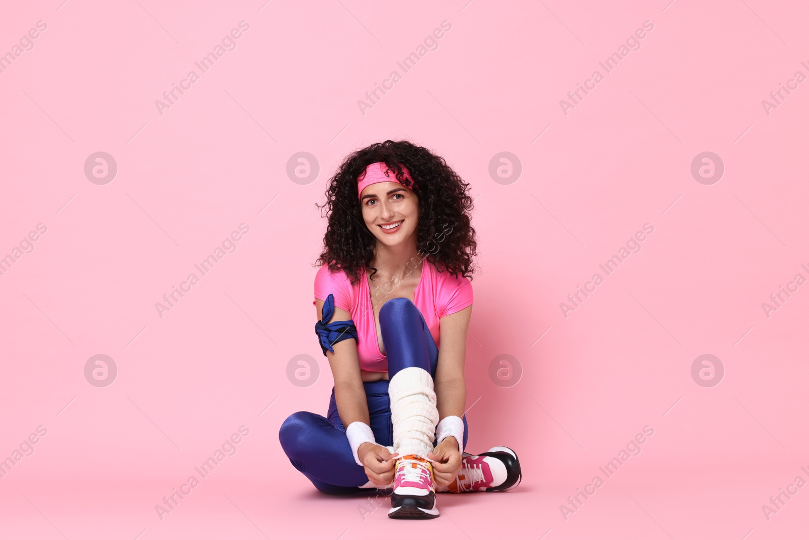 Photo of Aerobics. Happy woman in sportswear on pink background