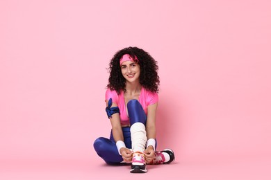 Aerobics. Happy woman in sportswear on pink background