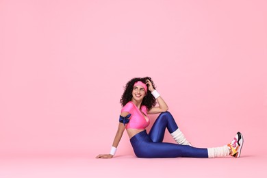 Photo of Aerobics. Happy woman in sportswear on pink background