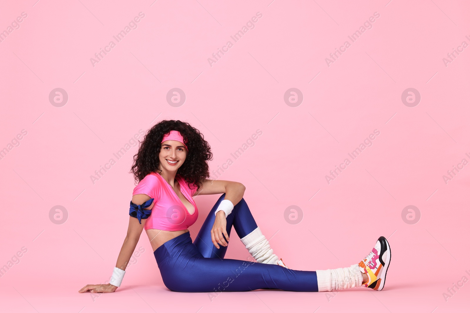 Photo of Aerobics. Happy woman in sportswear on pink background