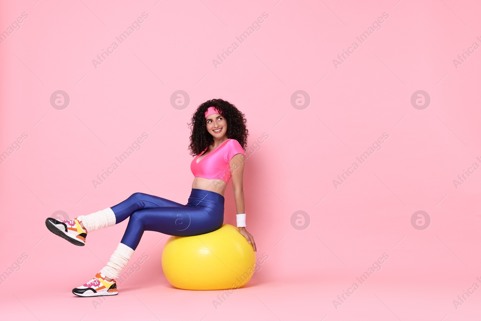 Photo of Aerobics. Happy woman with fitness ball on pink background