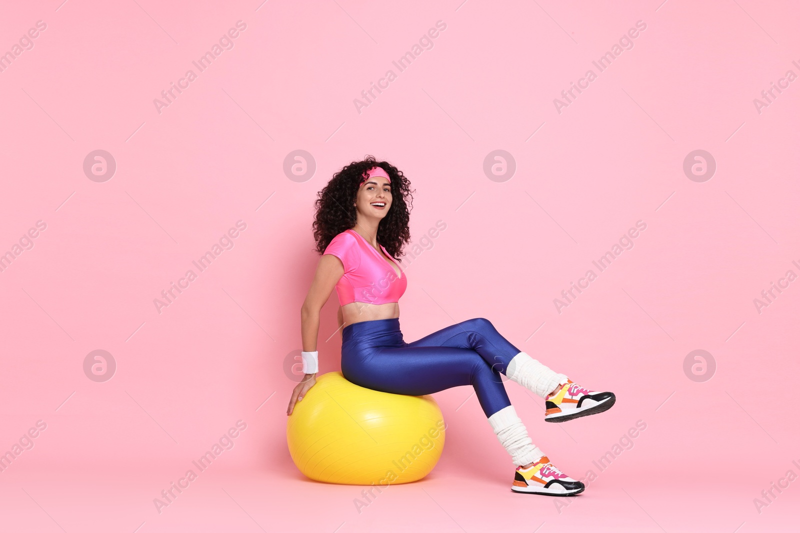 Photo of Aerobics. Happy woman with fitness ball on pink background