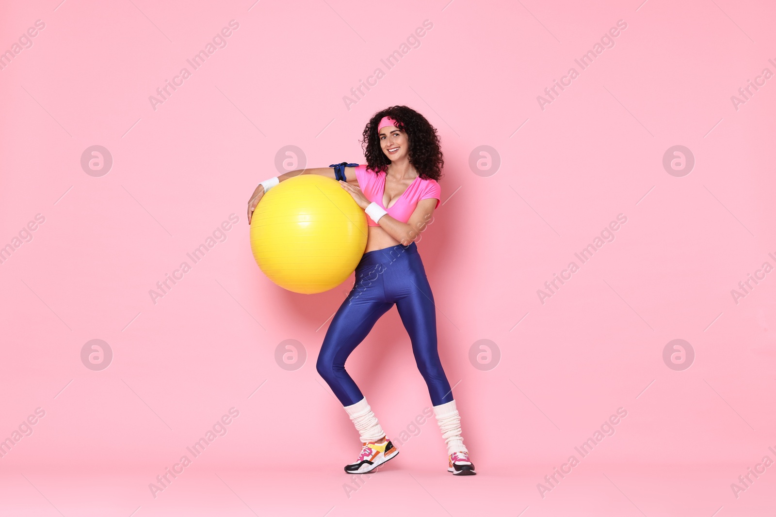 Photo of Aerobics. Happy woman with fitness ball on pink background