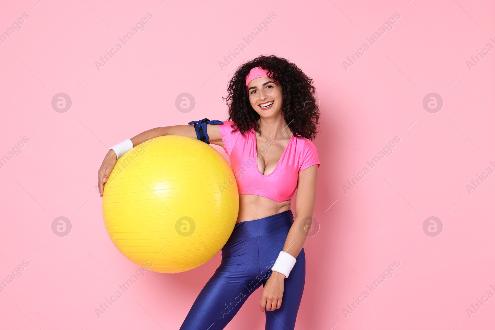 Photo of Aerobics. Happy woman with fitness ball on pink background