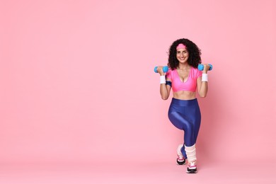 Woman doing aerobic exercise with dumbbells on pink background, space for text