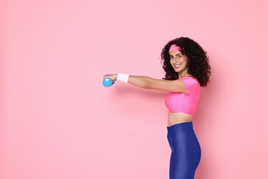 Woman doing aerobic exercise with dumbbells on pink background, space for text