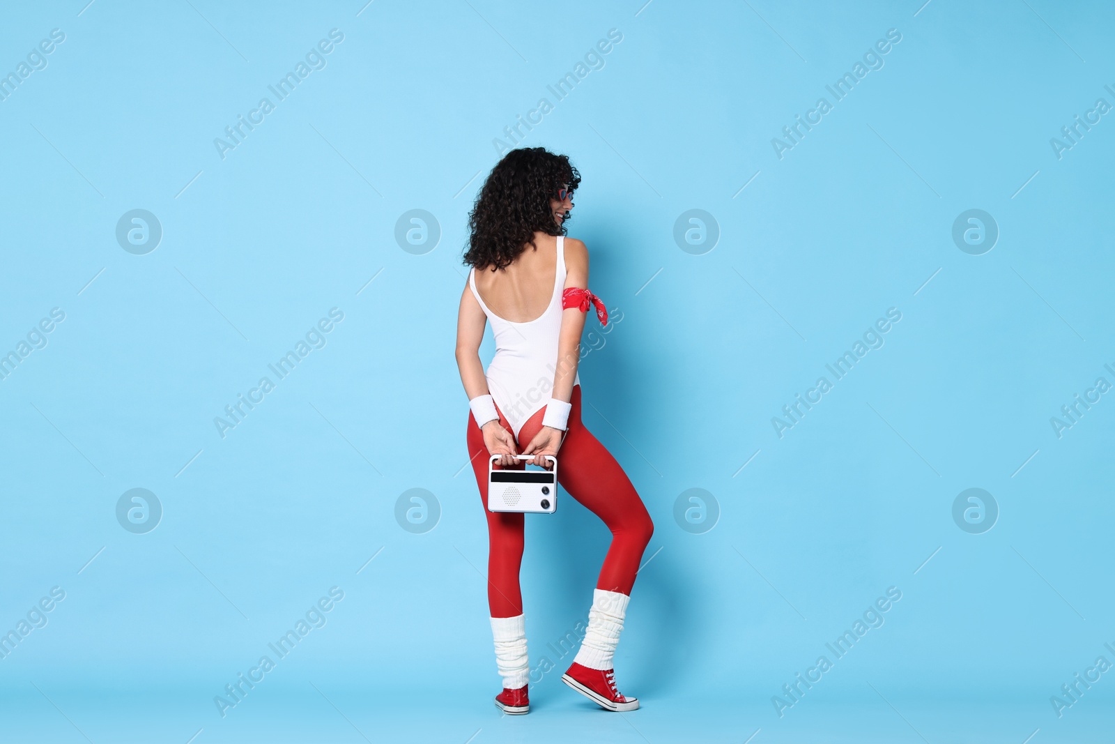 Photo of Aerobics. Happy woman with radio receiver on light blue background