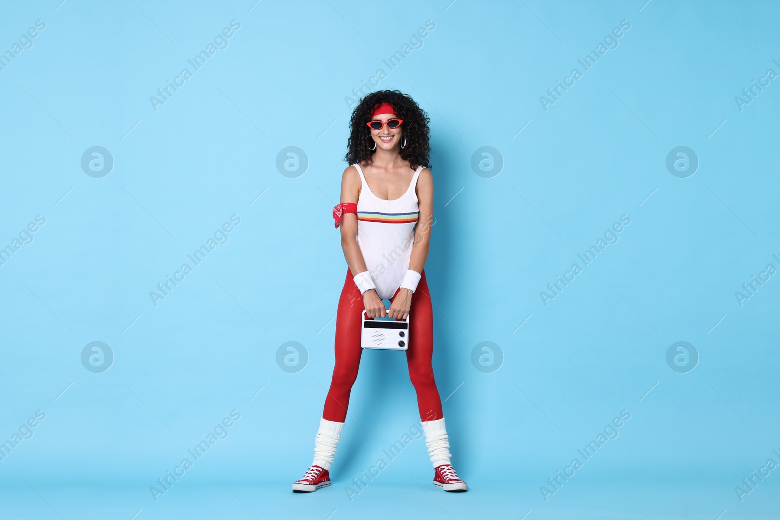 Photo of Aerobics. Happy woman with radio receiver on light blue background