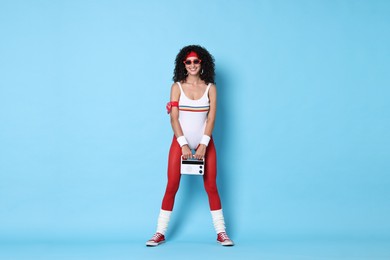 Photo of Aerobics. Happy woman with radio receiver on light blue background