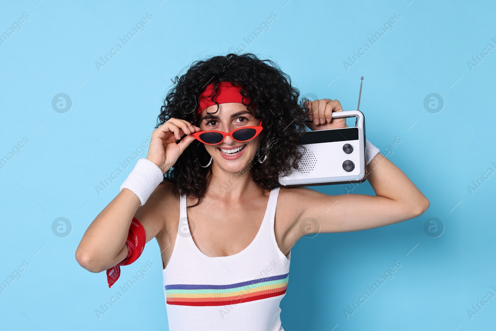 Photo of Aerobics. Happy woman with radio receiver on light blue background