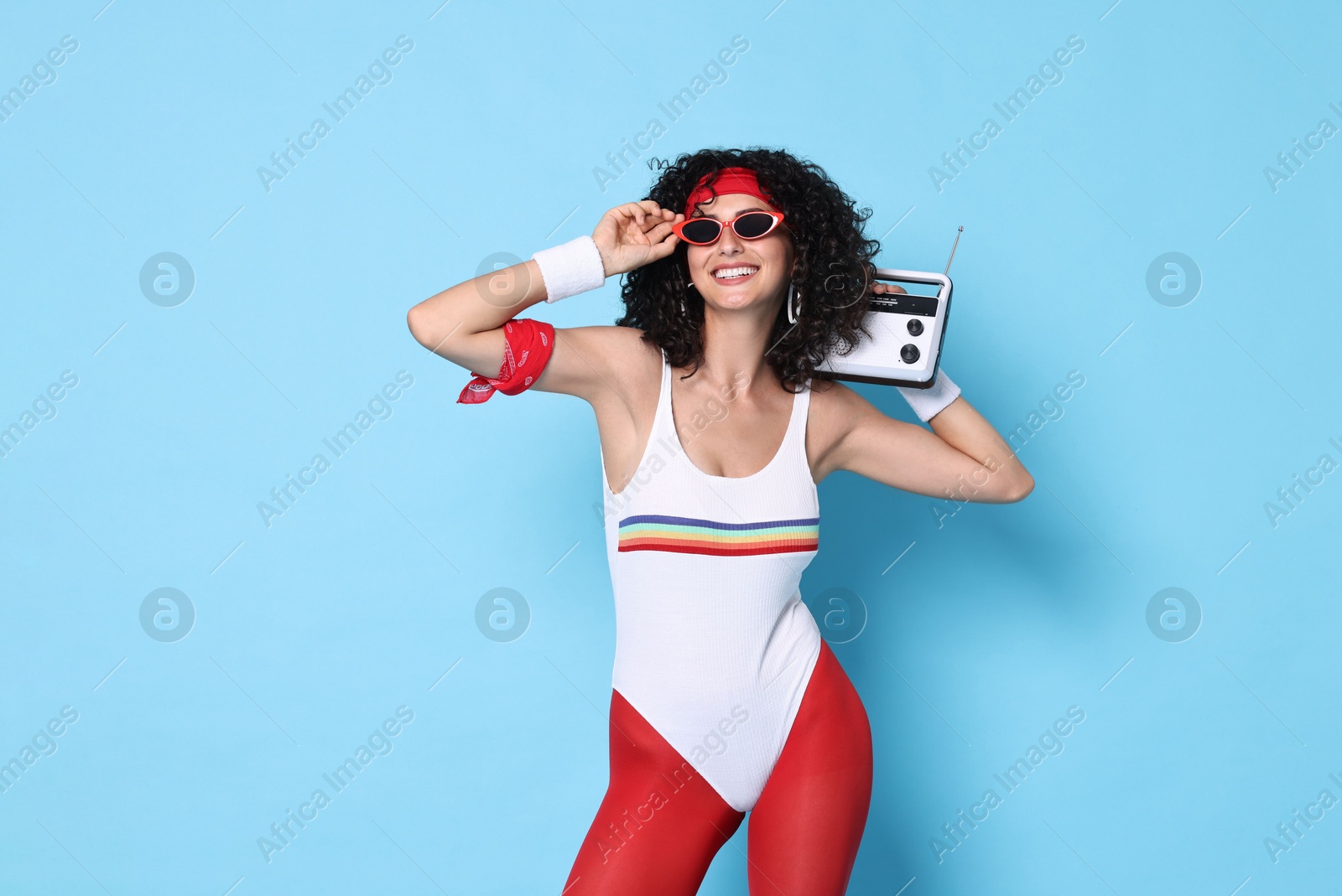 Photo of Aerobics. Happy woman with radio receiver on light blue background