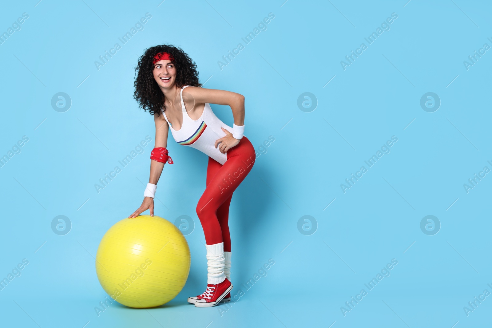 Photo of Aerobics. Happy woman with fitness ball on light blue background