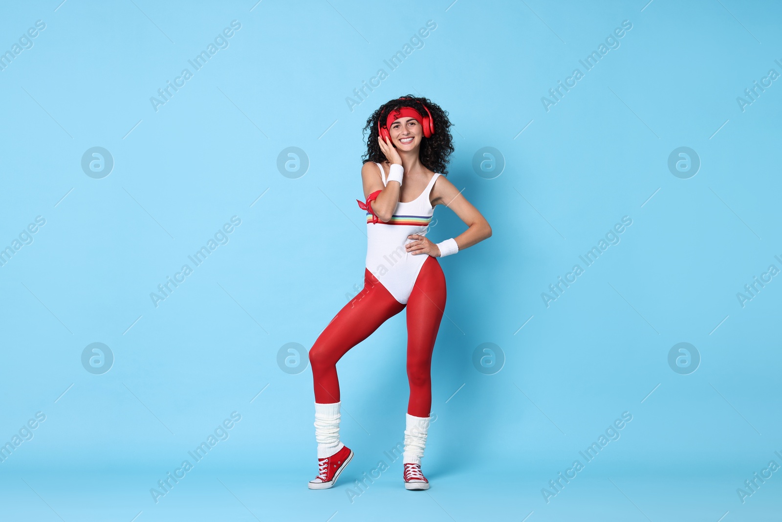 Photo of Aerobics. Happy woman in headphones on light blue background