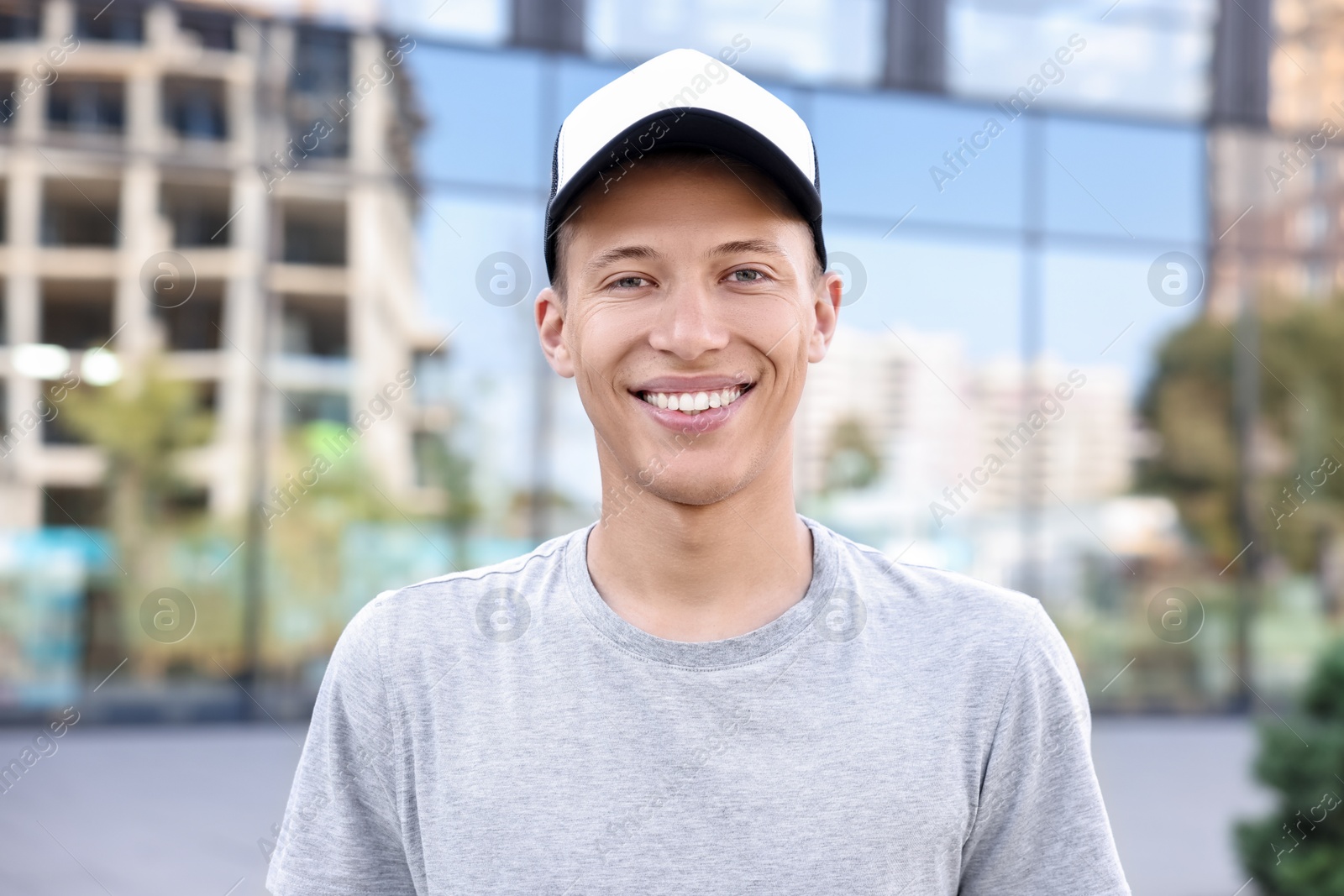 Photo of Portrait of smiling man in baseball cap outdoors