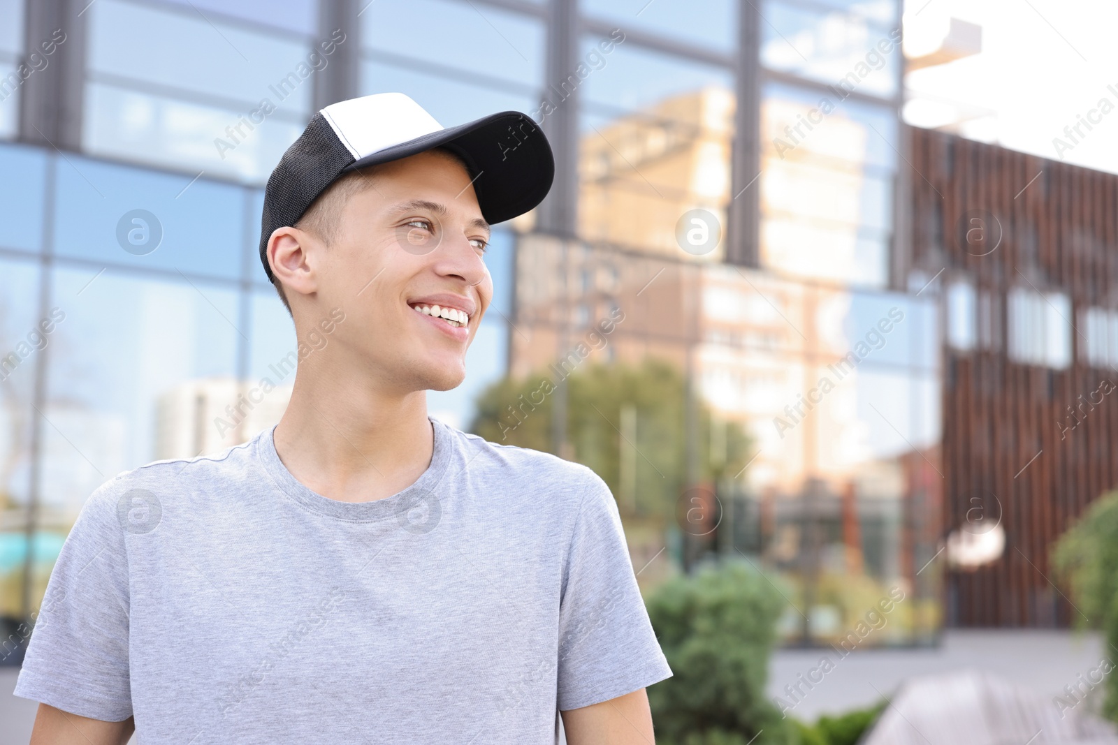 Photo of Portrait of smiling man in baseball cap outdoors. Space for text